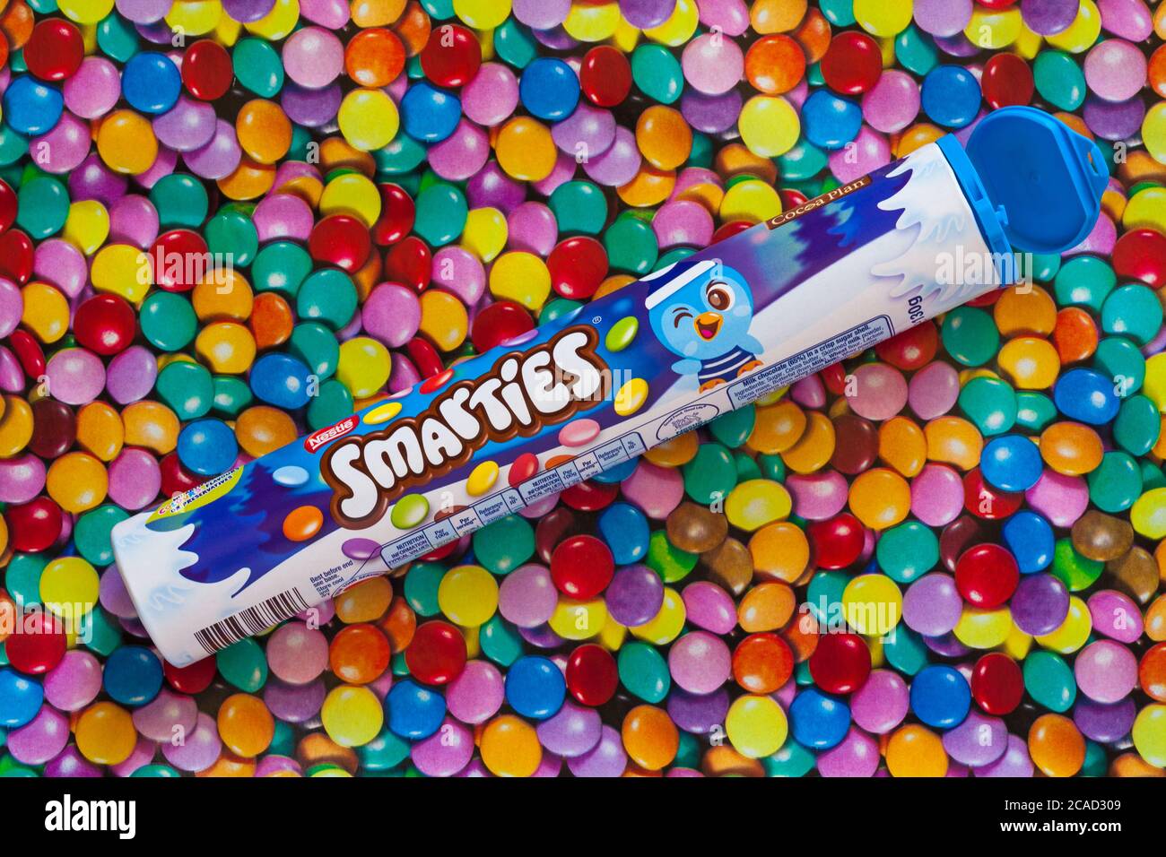 Nestle tube of Smarties set on colourful sweets background - candies sweets candy Stock Photo