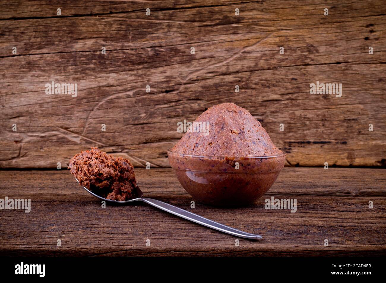 shrimp paste in glass cup on brown wooden background Stock Photo