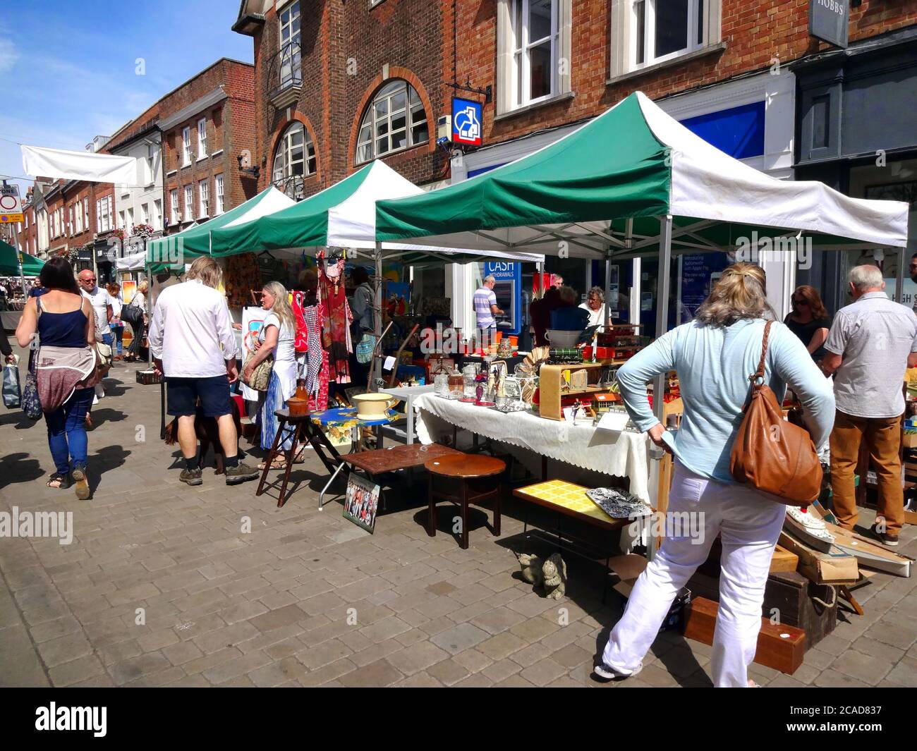 Winchester, UK - July 31, 2015:  Customers looking at antique and bric a brac stalls at the weekly street flea market which is a popular tourism trave Stock Photo