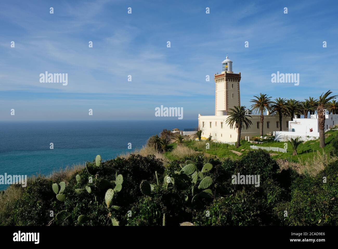 In Morocco Tangier white lighthouse near blue ocean. Sunny clouds skyline .  Cape Malabata with a lighthouse Stock Photo