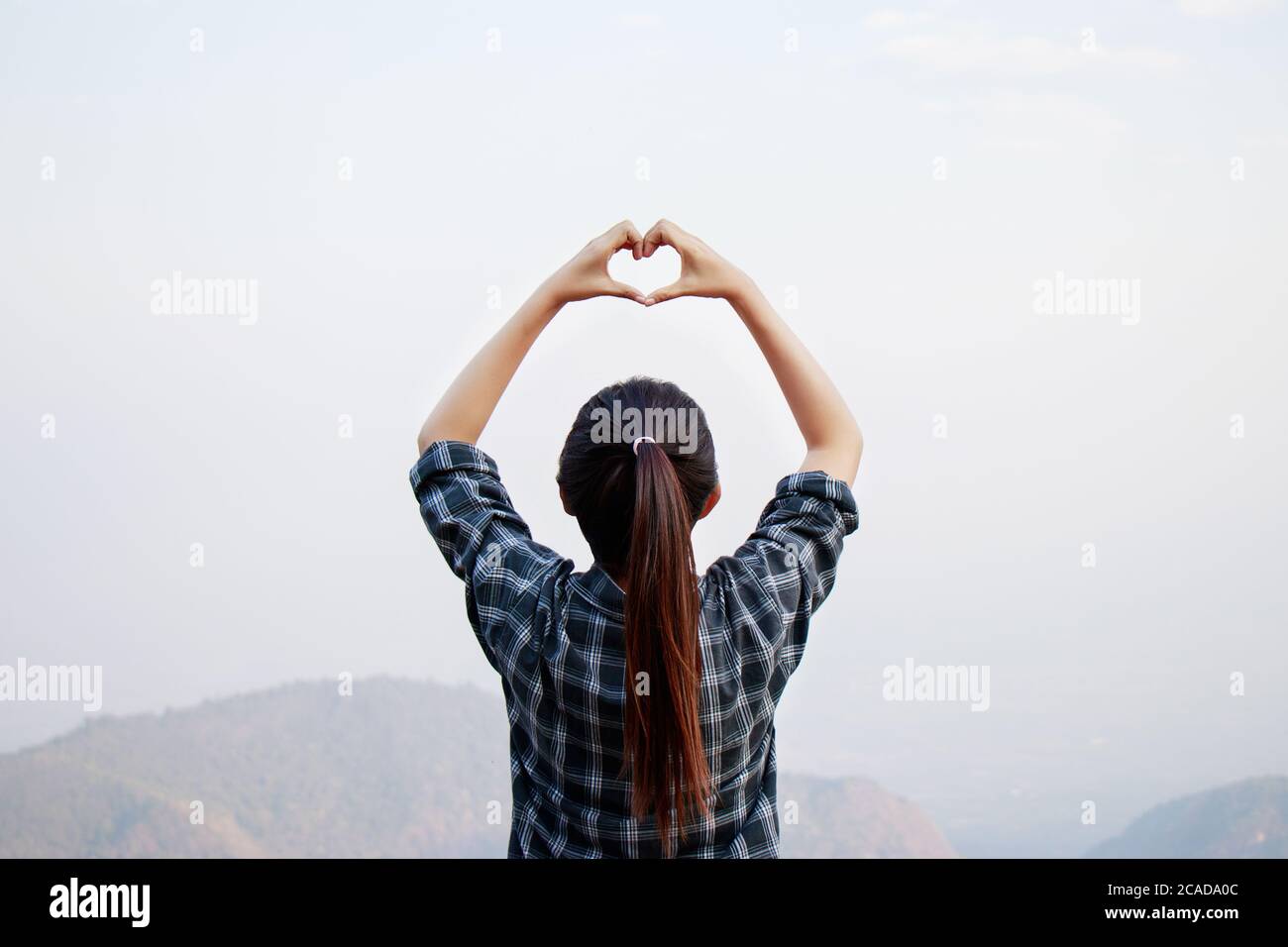 I love travel concept : Freedom traveler woman standing with heart shaped hands and enjoy a wonderful nature Stock Photo