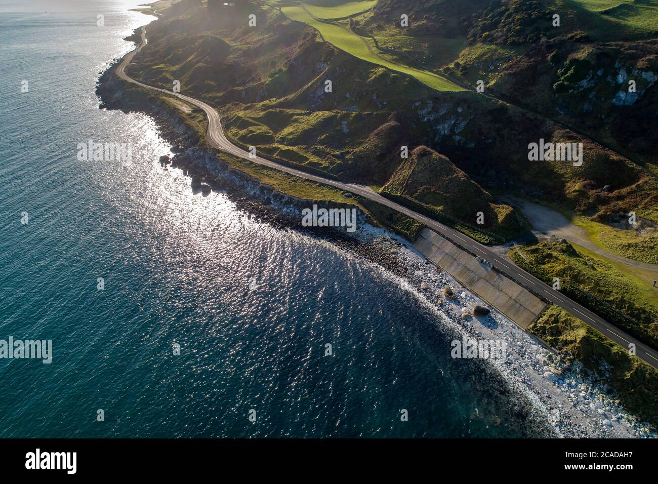 Causeway Coastal Route a.k.a Antrim Coast Road A2 on the Atlantic coast in Northern Ireland. One of the most scenic coastal roads in Europe. Aerial vi Stock Photo