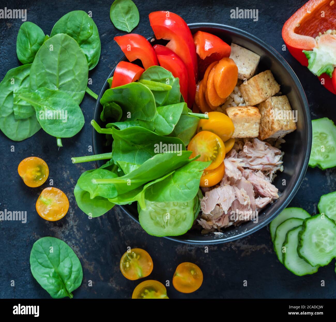 Healthy balanced lunch of canned tuna, brown rice, tofu, and vegetables
