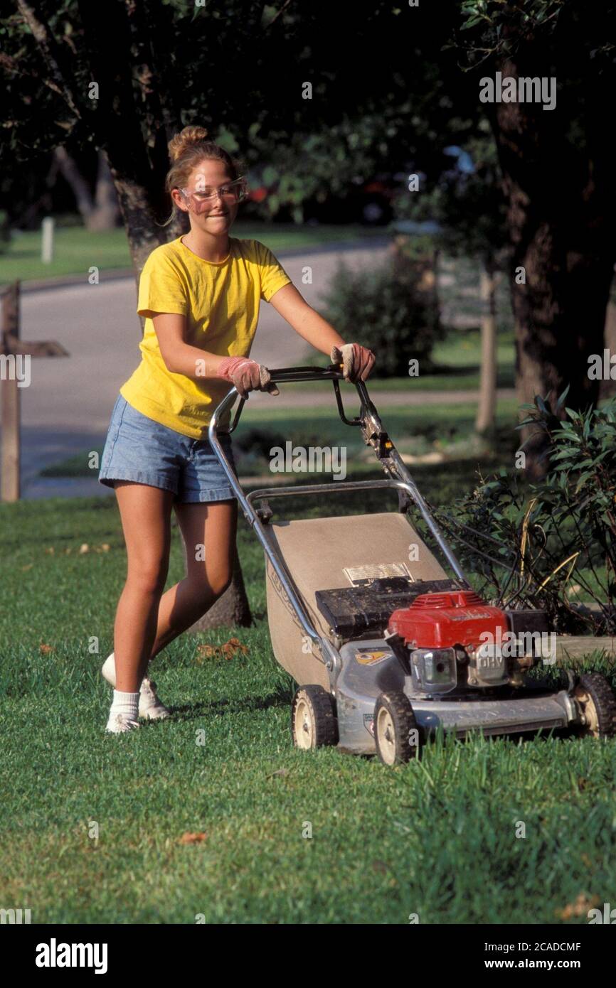 Austin Texas USA 15yearold girl wearing safety glasses mows lawn