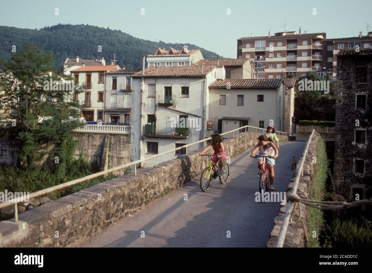 Girls ride their bicycles over a bridge in the northwestern countryside