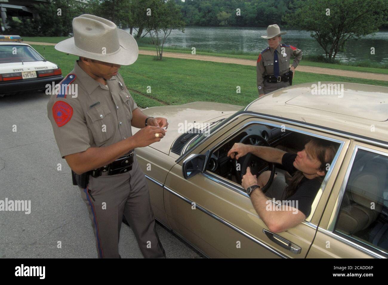 Texas Department of Public Safety Hispanic male and Anglo female officers stop driver on suspected stolen goods charge. ©Bob Daemmrich Stock Photo