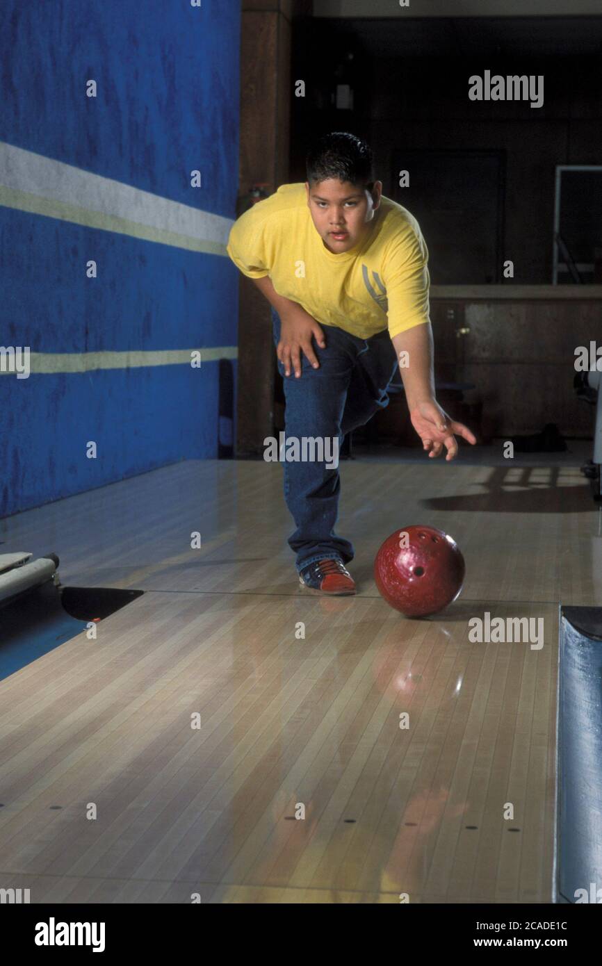 Hispanic boy (13) bowling with bowling ball in Texas bowling alley. ©Bob Daemmrich Stock Photo