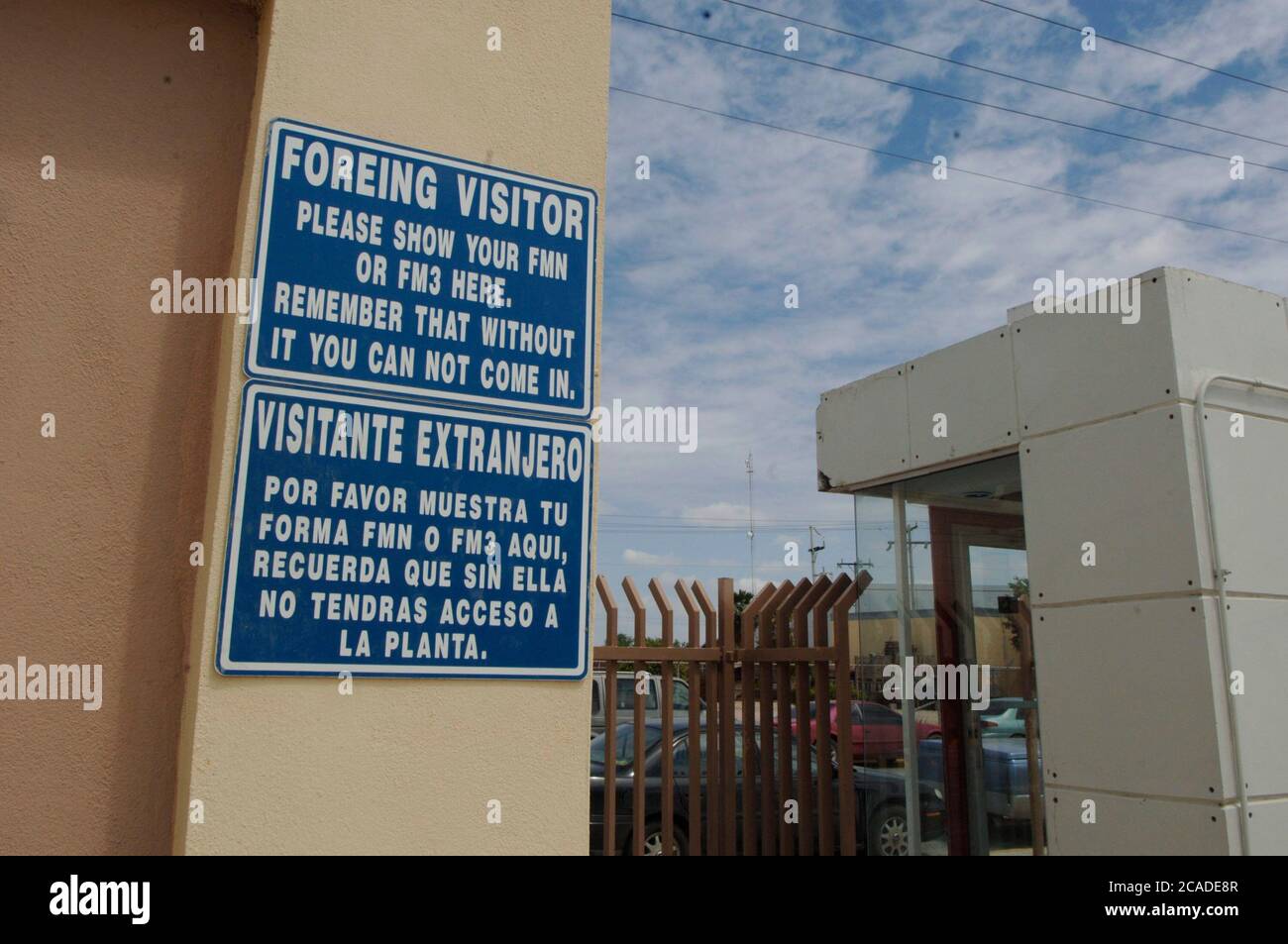 Matamoros, Mexico April, 2006: Bilingual signs outside a maquiladora manufacturing plant across the United States border from Brownsville, Texas.  ©Bob Daemmrich Stock Photo