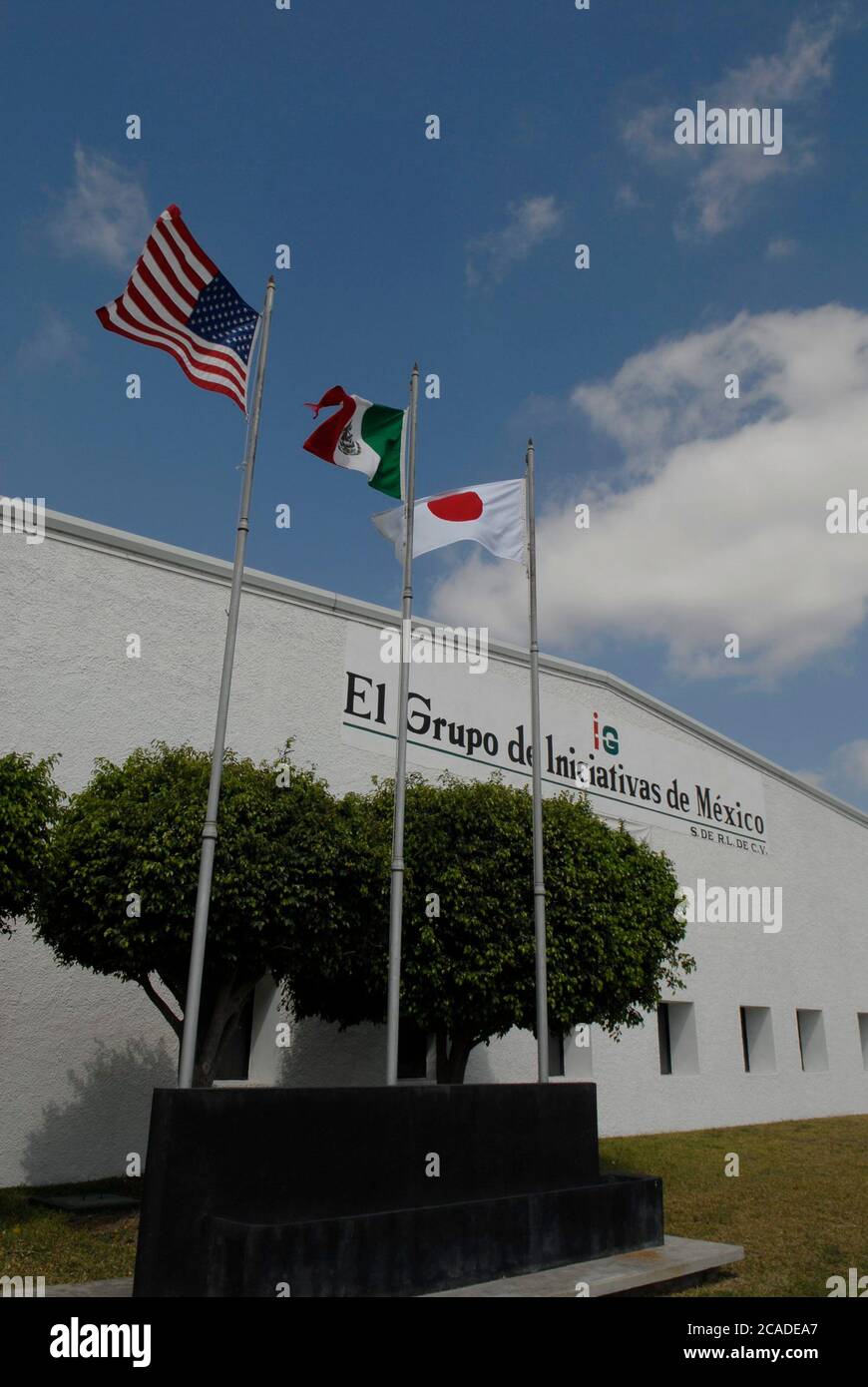 Matamoros, Mexico, April 2006: Flags of the United States, Mexico and Japan fly in front of the offices of Japanese-owned The Initiative Group, El Grupo Iniciativas de Mexico. The company assembles camera and cabinet components for Fuji at the maquiladora facility just across the U.S. border from Brownsville, Texas   ©Bob Daemmrich Stock Photo