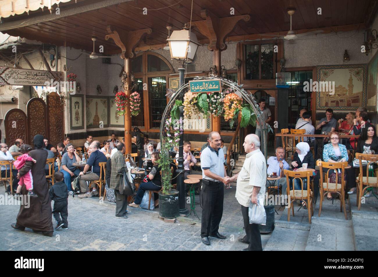 Customers sitting in the busy outdoor section of the famous Al Nofara cafe, the oldest coffee shop in the old city of Damascus, Syria. Stock Photo