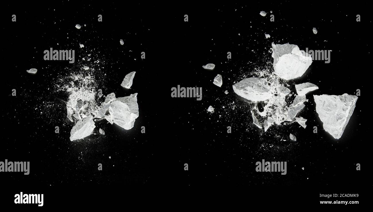 Splash, destroy, explosion by white pieces plaster, stone, chalk on black background Stock Photo