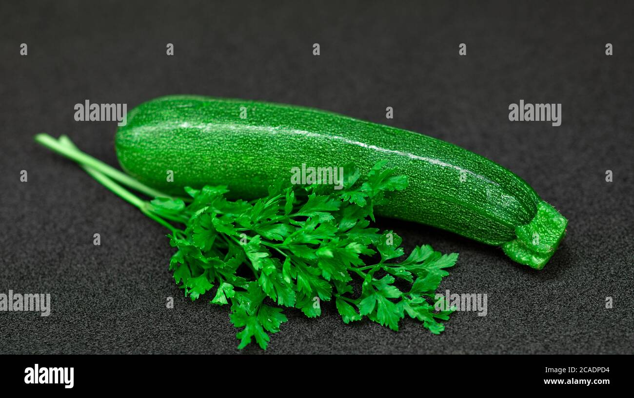 Fresh green zucchini and parsley on a dark background Stock Photo