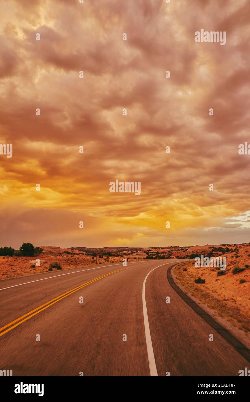 Golden sunset over storm clouds along empty highway in Moab, Utah Stock ...