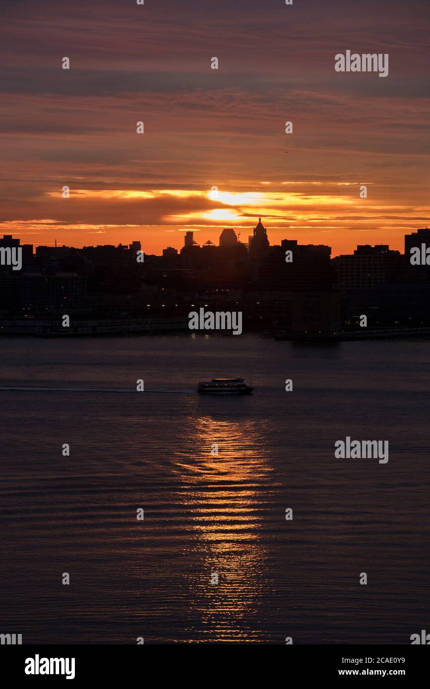 Sunrise light silhouettes NYC buildings and boat Stock Photo - Alamy