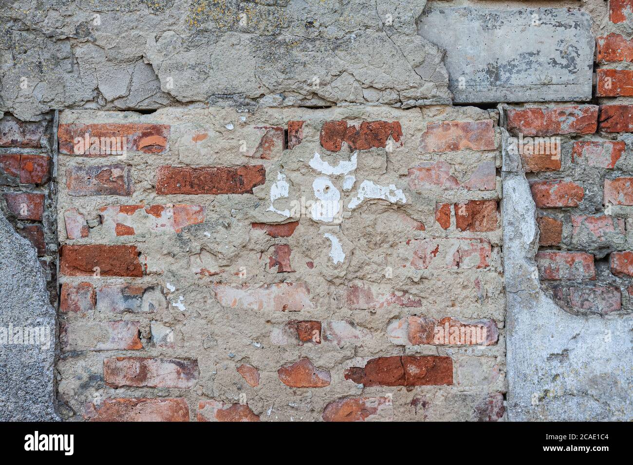 background from the texture of an old brick wall with ruined concrete. Stock Photo