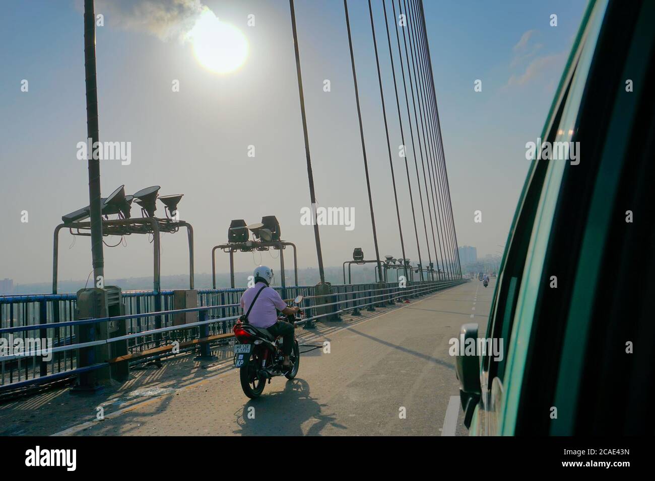 Kolkata, West Bengal, India - 25th July 2020 : Sun rays in blue sky over 2nd Hoogly Bridge, connecting Howrah and Kolkata. Stock Photo