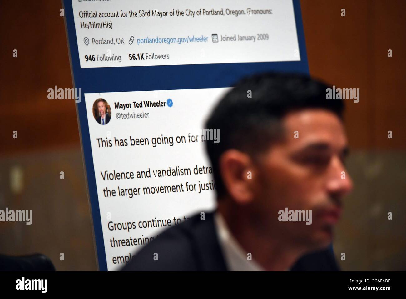 The tweets from Portland Mayor Ted Wheeler are displayed behind acting United States Secretary of Homeland Security Chad F. Wolf, who is appearing before the US Senate Homeland Security and Governmental Affairs Committee on August 6, 2020 in Washington, DC to explain the use of federal agents during protests in Portland, Oregon. Credit: Toni Sandys/Pool via CNP | usage worldwide Stock Photo