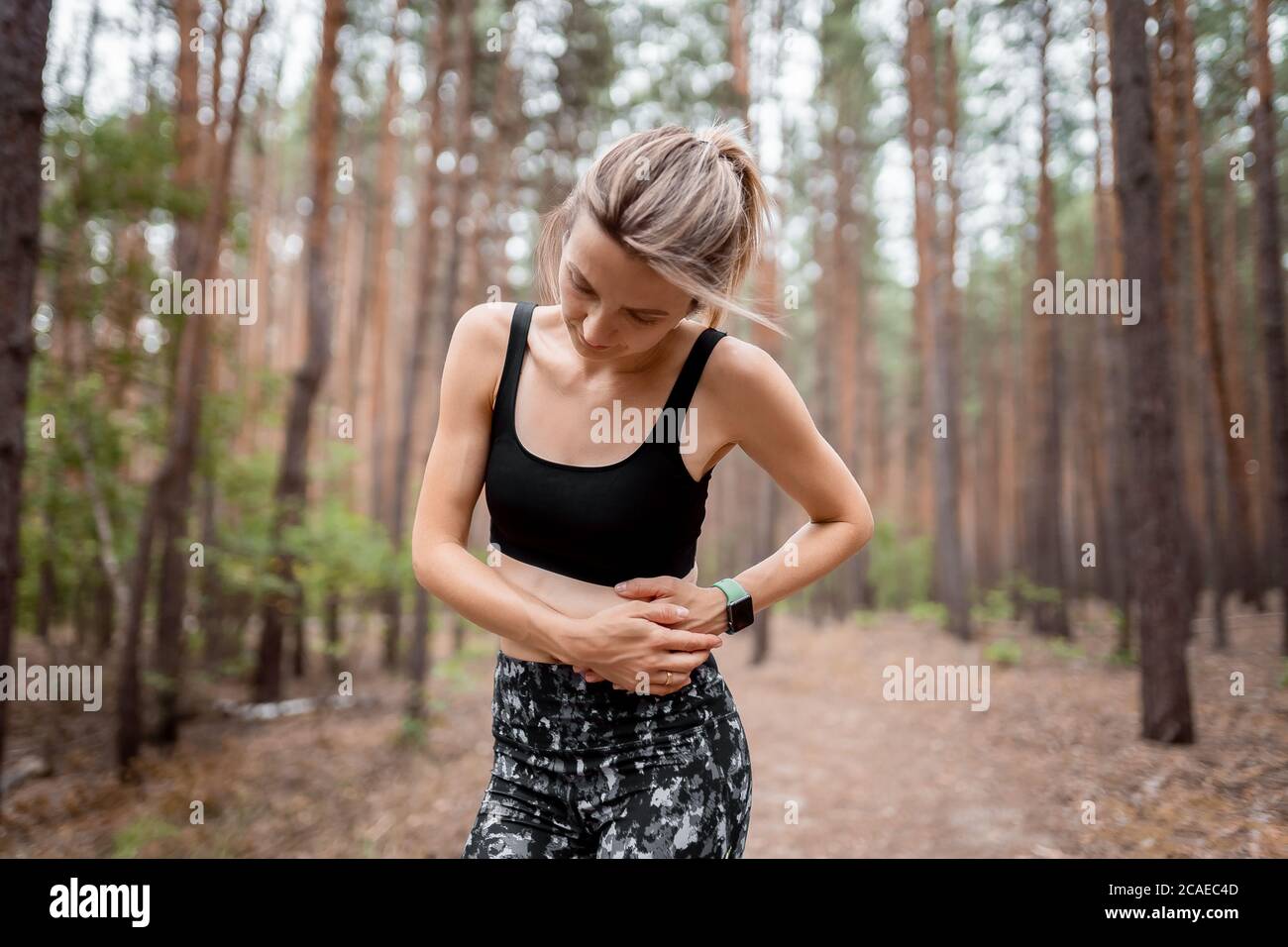 Side stitch woman runner side cramps after running. Jogging woman with stomach side pain after