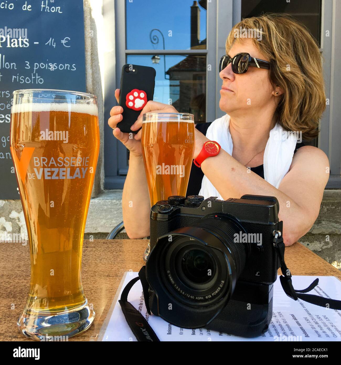Digital camera, glasses of beer and good looking mature friend, illustration for a photographer's way of life, Vezelay, Yonne, Bourgogne Franche-Comté, France Stock Photo