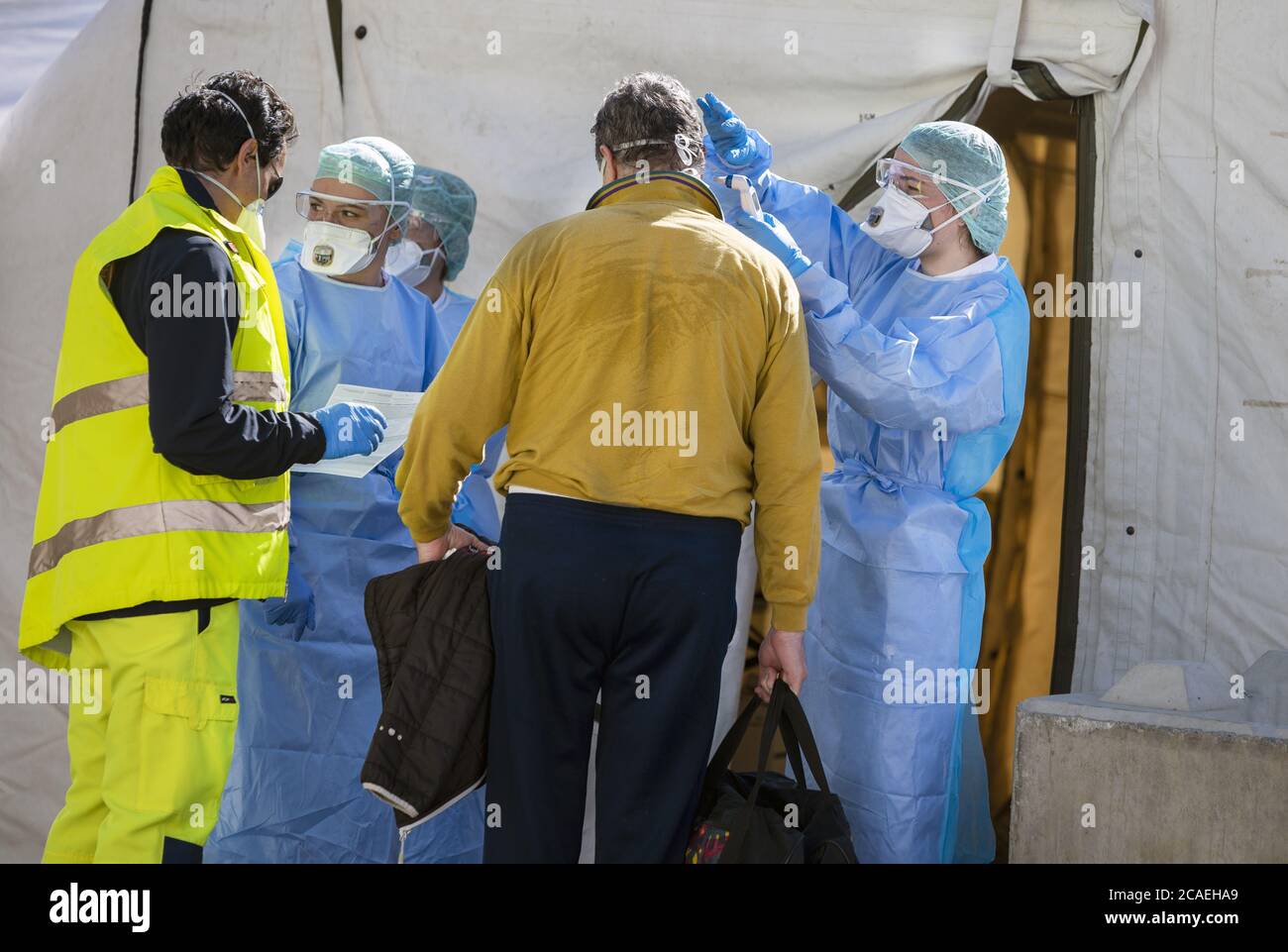 Alert pandemic Covid-19. Triage hospital tent for the first AID for patient infected with Corona Virus. Doctors check the patiences at the entrance. Stock Photo