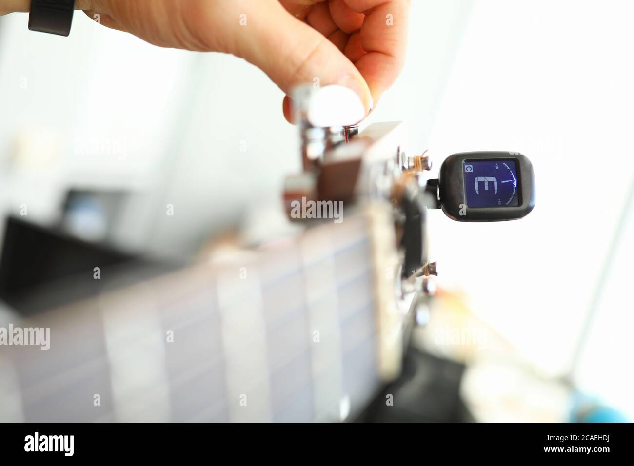 Tuning acoustic or electric guitar with device Stock Photo Alamy