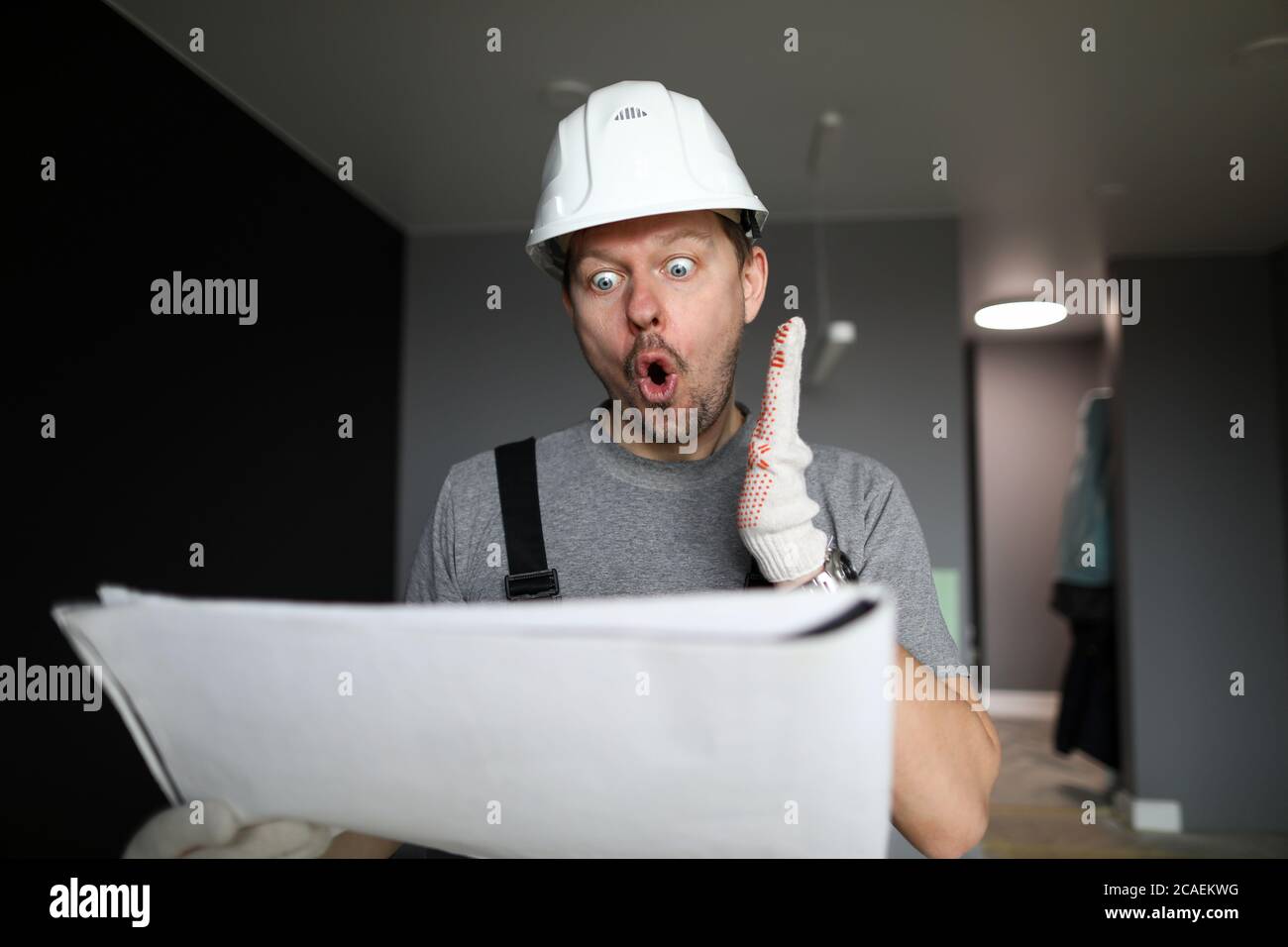 Shocked handyman or engineer looking at scheme Stock Photo