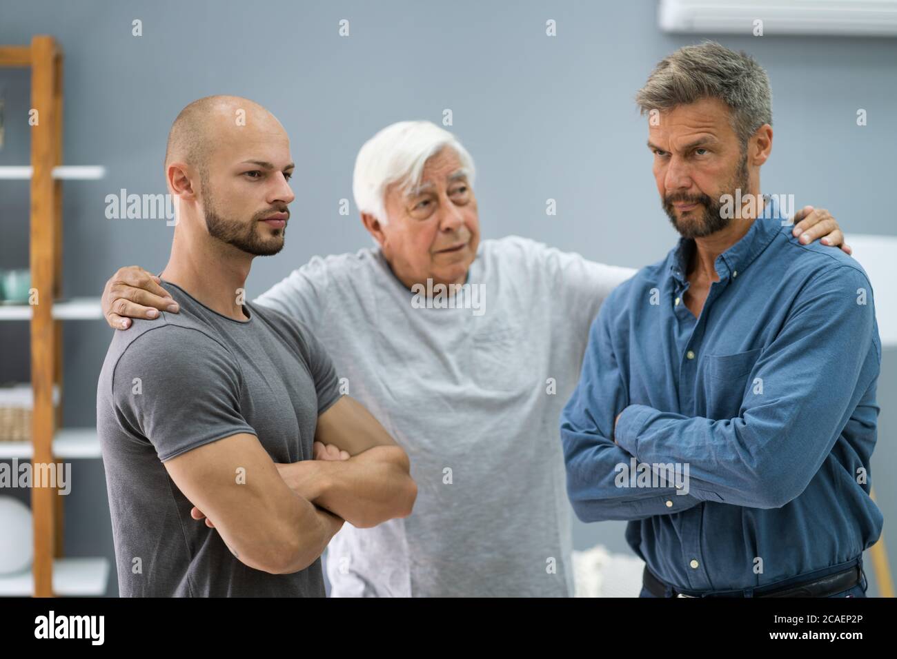 Grandfather Mediating In Father And Son Conflict Stock Photo