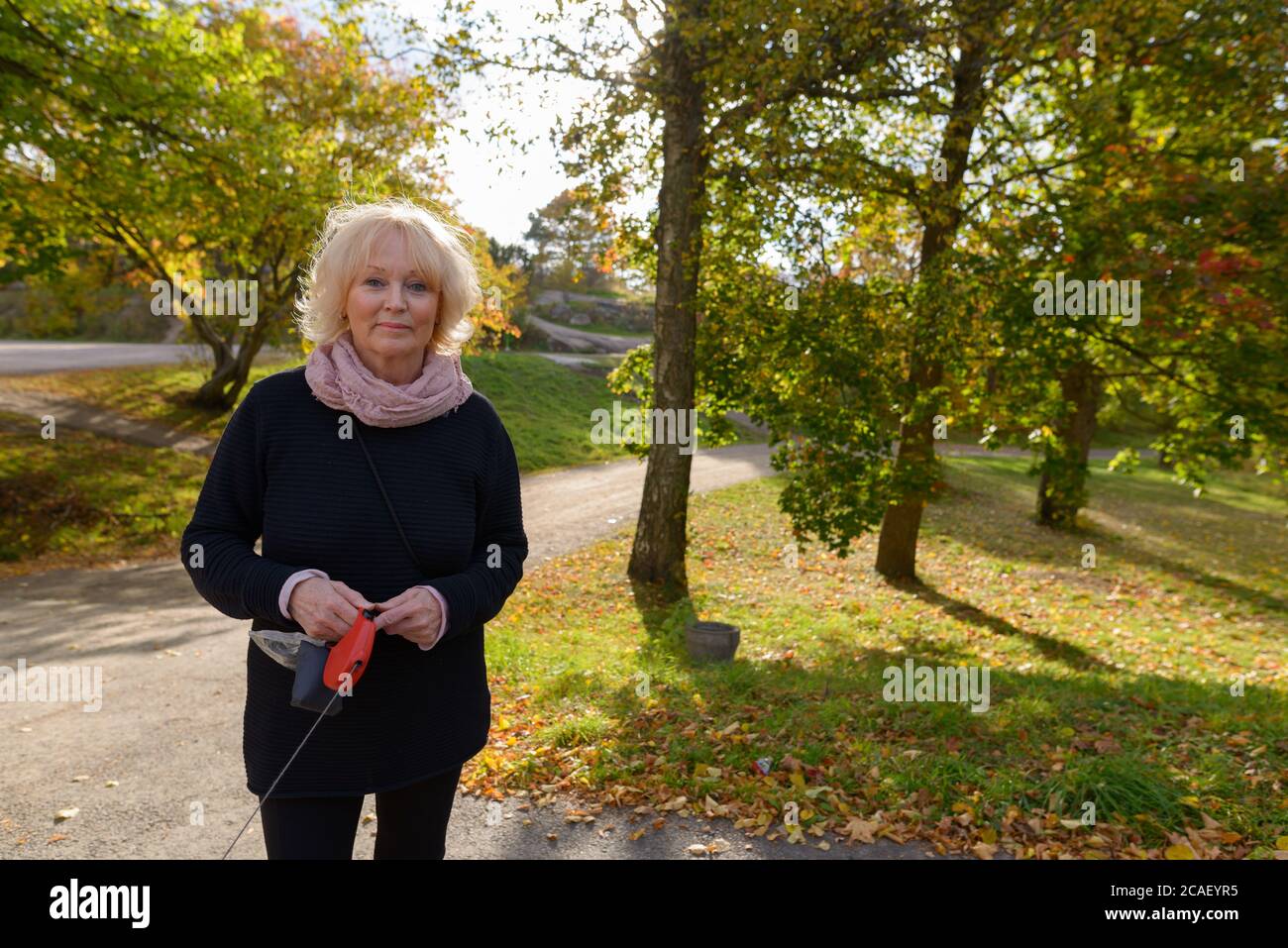 Senior woman walking on the path of quiet and relaxing natural park Stock Photo