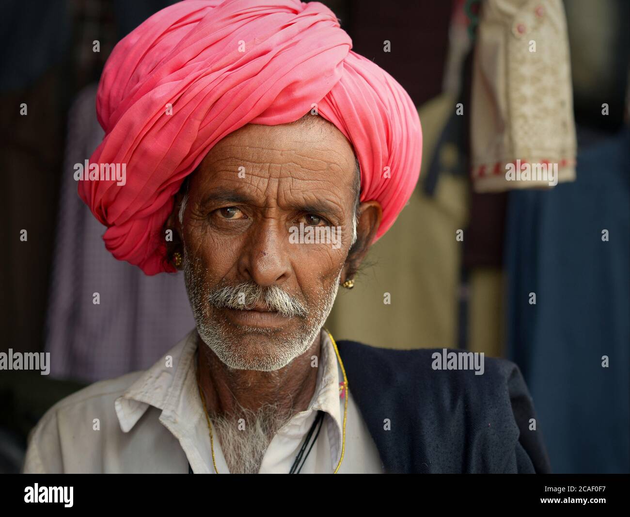 Elderly Indian Rajasthani man with pink turban poses for the camera. Stock Photo
