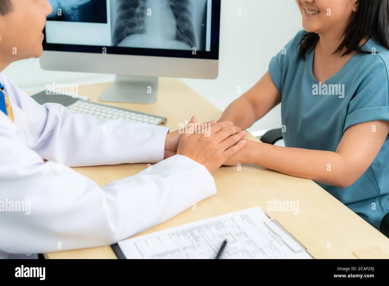 Close up of man doctor touching patient hand for encouragement and empathy on the hospital, cheering and support patient, Bad news, medical examinatio Stock Photo