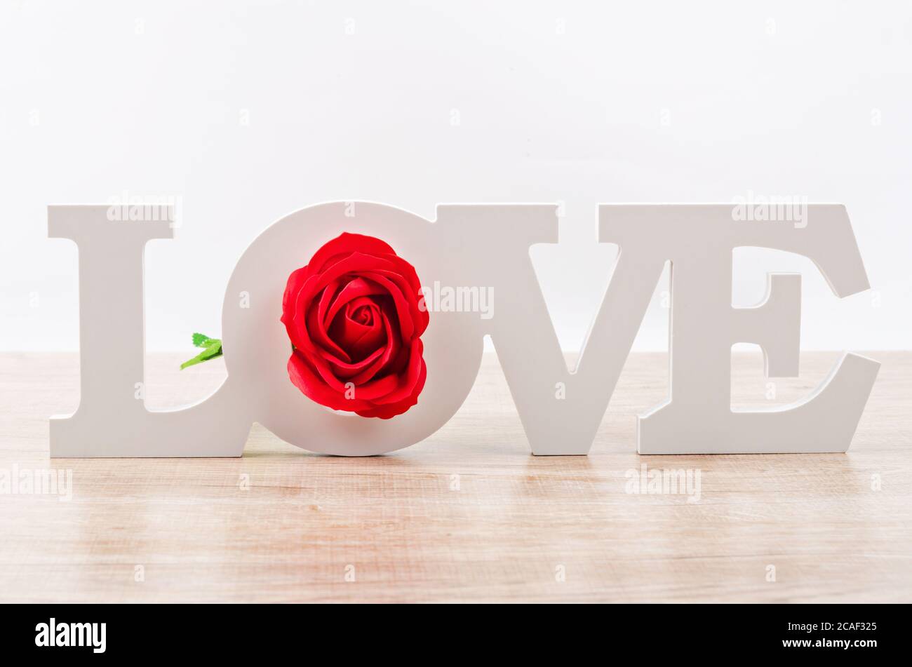 White wooden love letters with red rose on table. Stock Photo