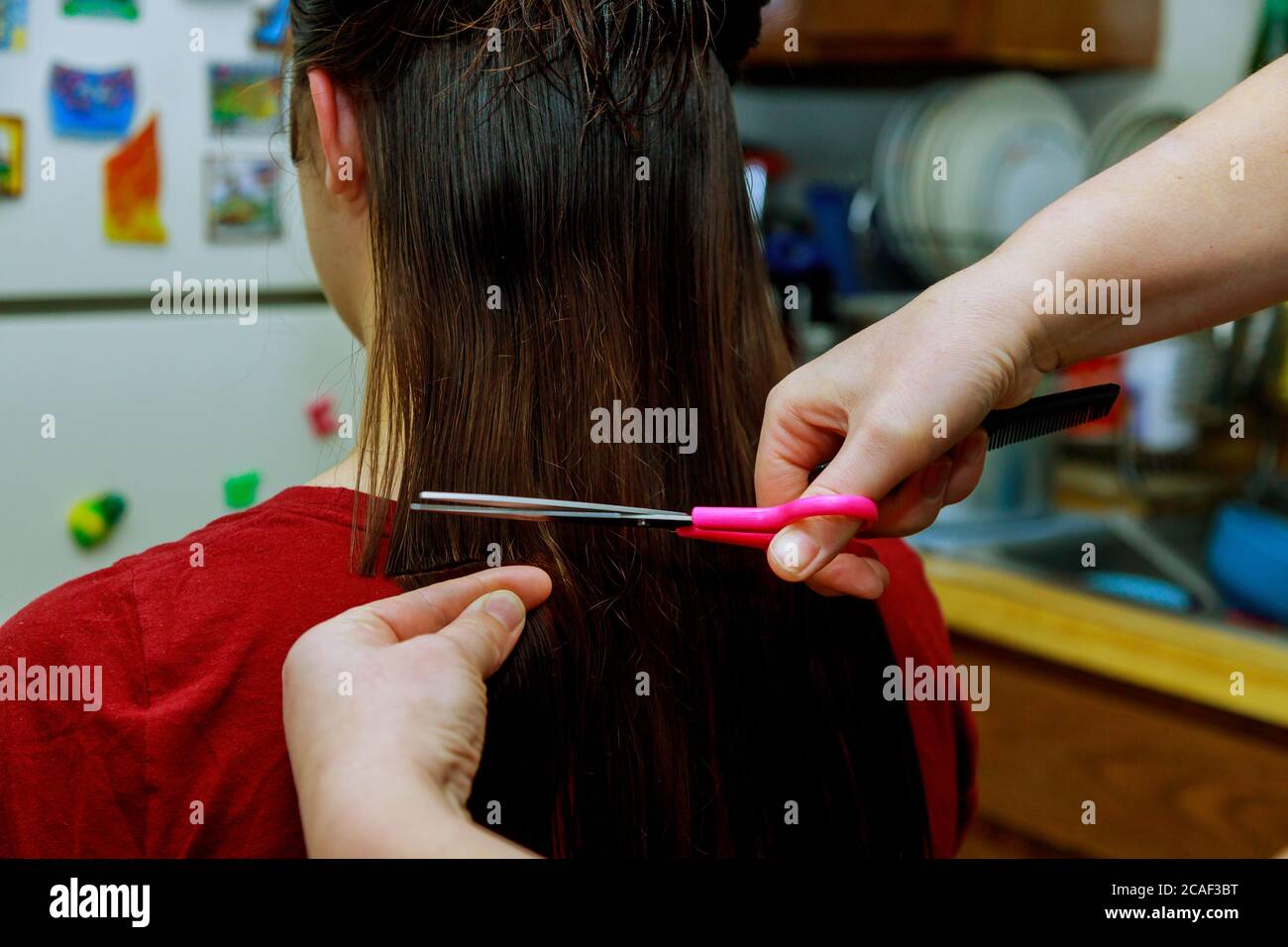 Mom cuts hair girl with scissors at home making a hair style Stock Photo -  Alamy