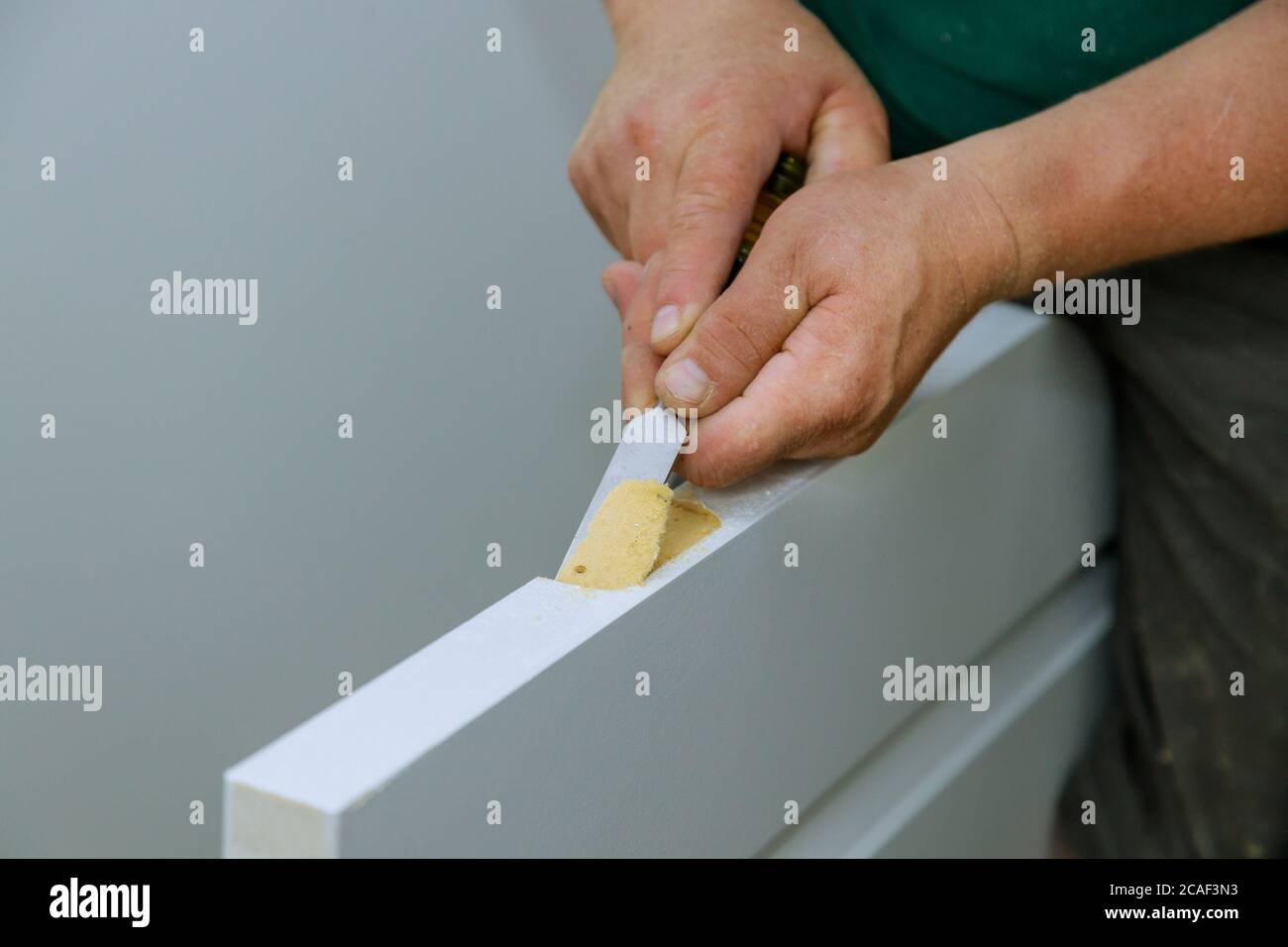 Carpenter working using a chisel a hinge wooden door a hinge is