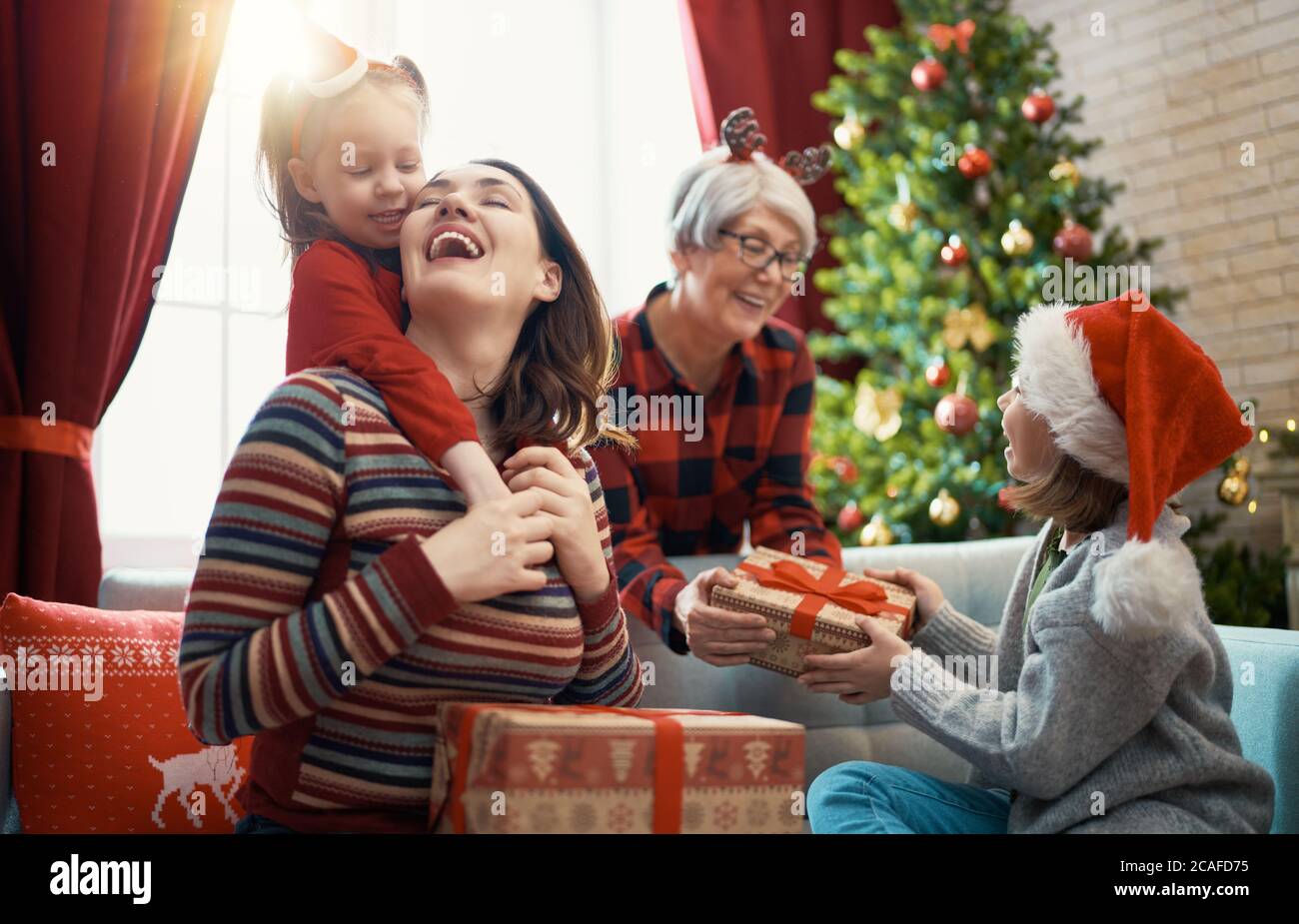 Merry Christmas Happy Holidays Cheerful Kids Presenting Gifts Mom Granny  Stock Photo by ©choreograph 523580328