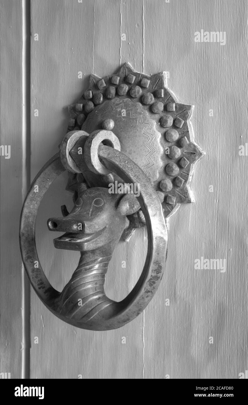 A door knocker with a dragon-shaped handle. Stock Photo