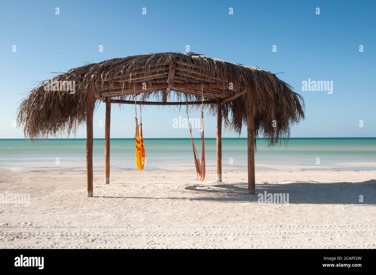 Natural and tropical hut on the beach Caribbean Ocean Front, desert beach whit hammock on a beach in Holbox Island, Mexico Stock Photo