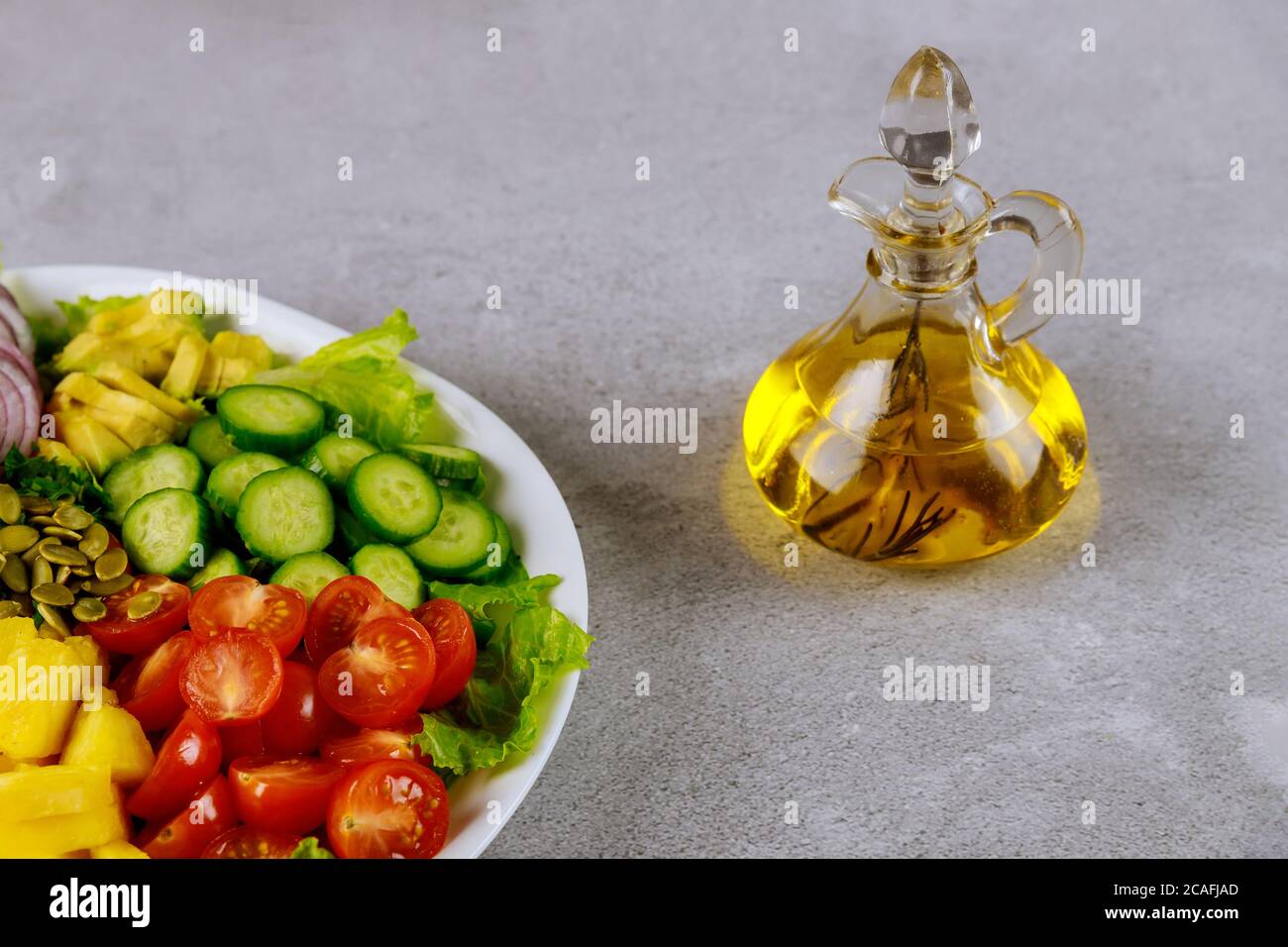 Vegetable salad with herb olive oil in glass bottle. Stock Photo