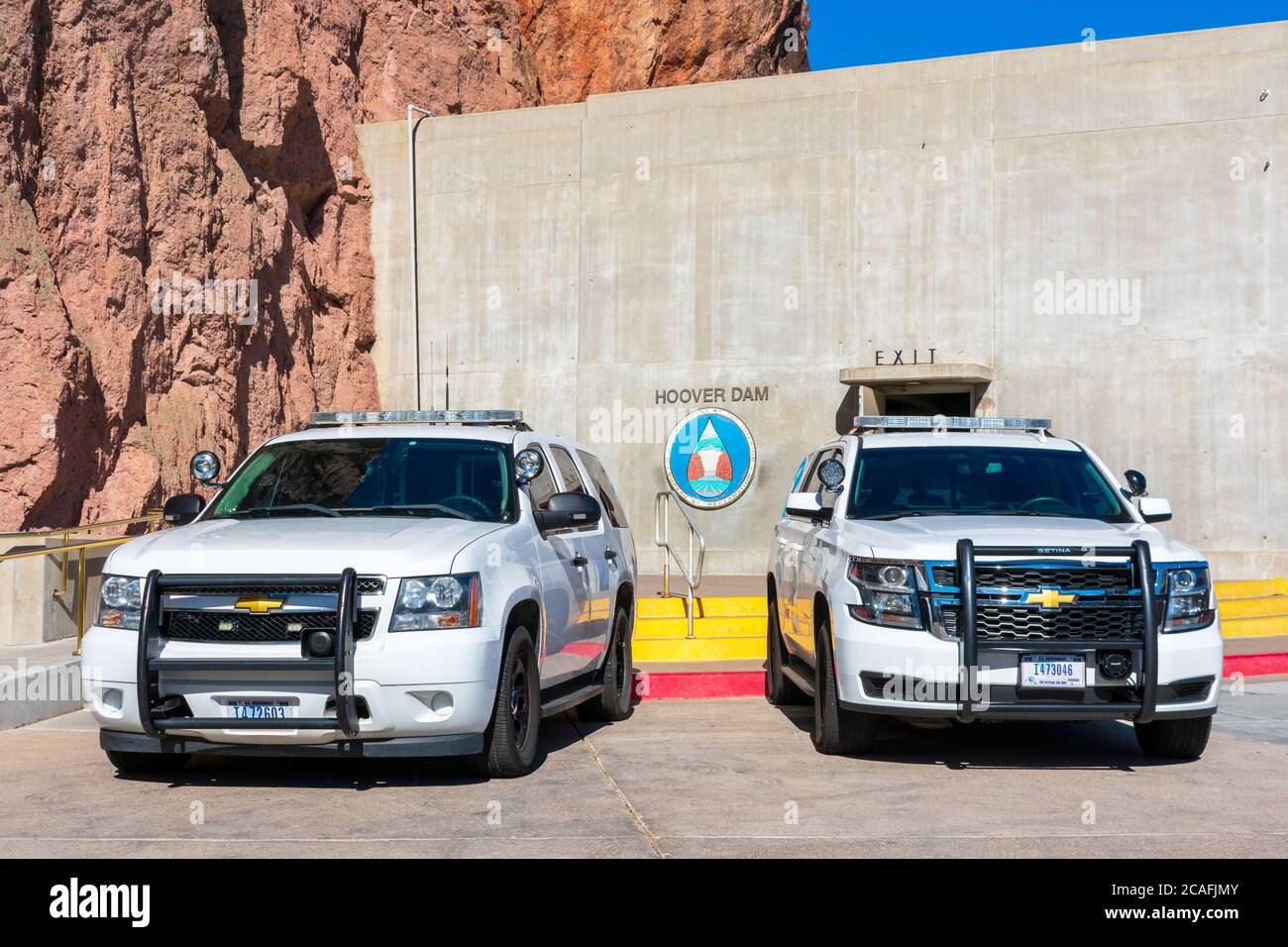 Two Chevrolet SUVs white base model service vehicle wearing U.S. government plates registered to the Department of the Interior parked at Hoover Dam - Stock Photo