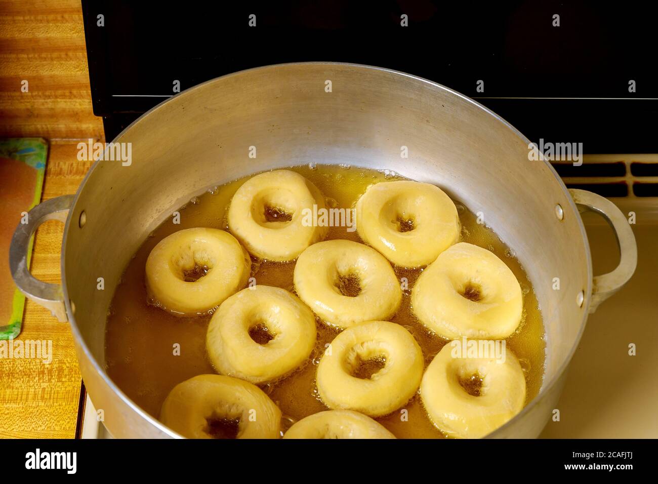Frying round donuts with hole in hot oil Stock Photo Alamy