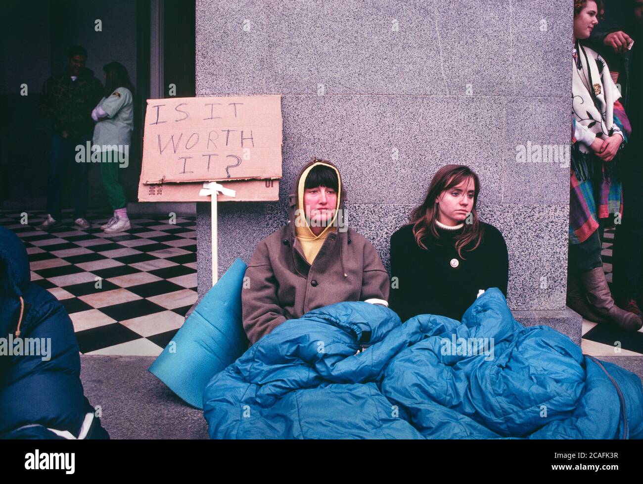 Two women sitting at the entrance to the U.S. federal building in Sacramento, California (state capital) during one of the many anti-gulf war protests that took place in cities and on university campuses across the United States after Operation Desert Storm in January 1991. Stock Photo