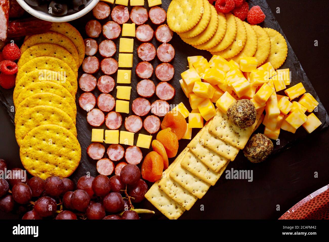Football made from cheese and sausage for charcuterie board on wooden