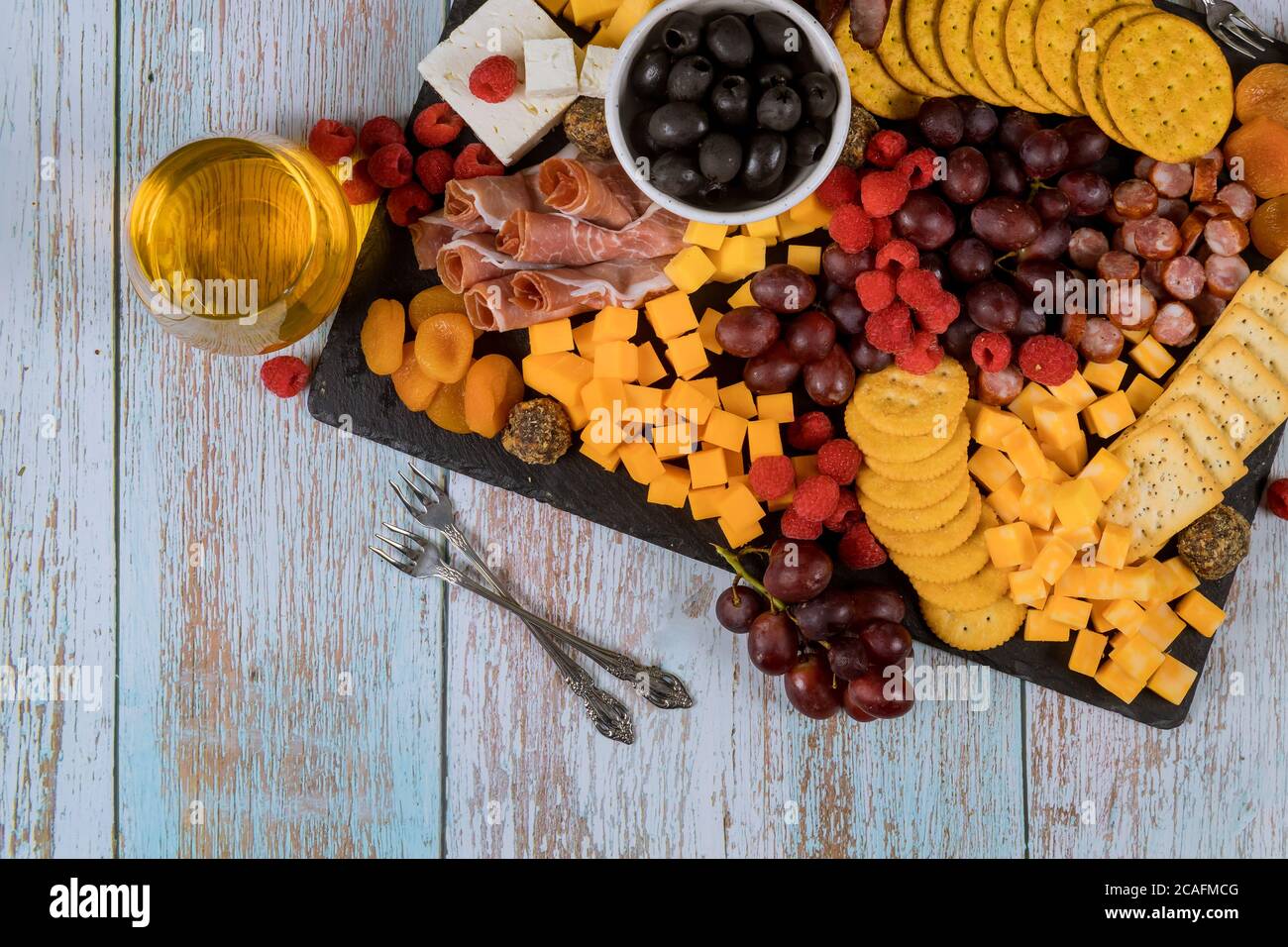 Charcuterie board with cheese, grape, raspberry meat, crackers and drink Stock Photo Alamy