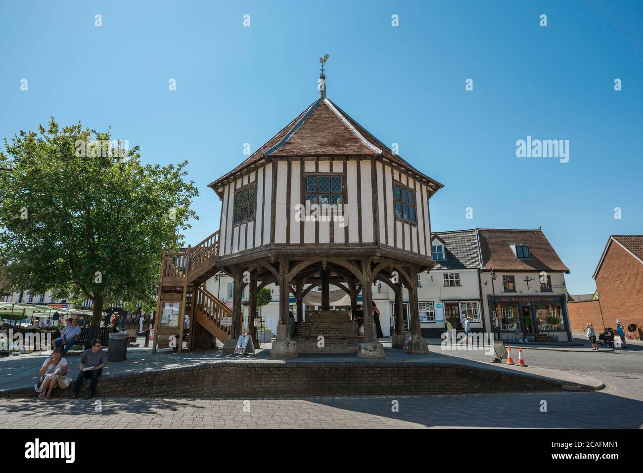 Market cross England, view in summer of people relaxing beside the historic Market Cross in the centre of the town of Wymondham, Norfolk, England, UK Stock Photo