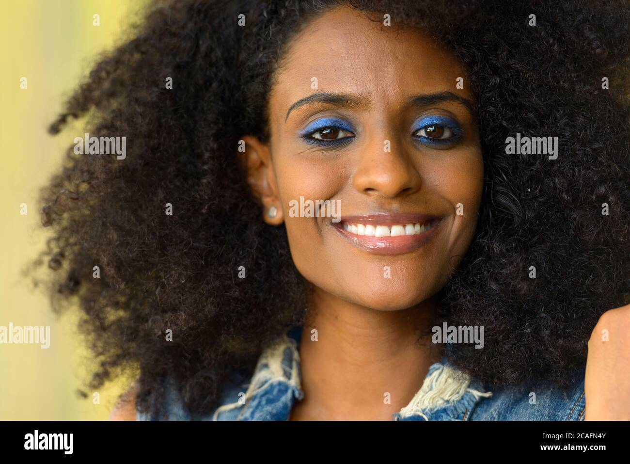 Happy young beautiful African woman with Afro hair outdoors Stock Photo ...