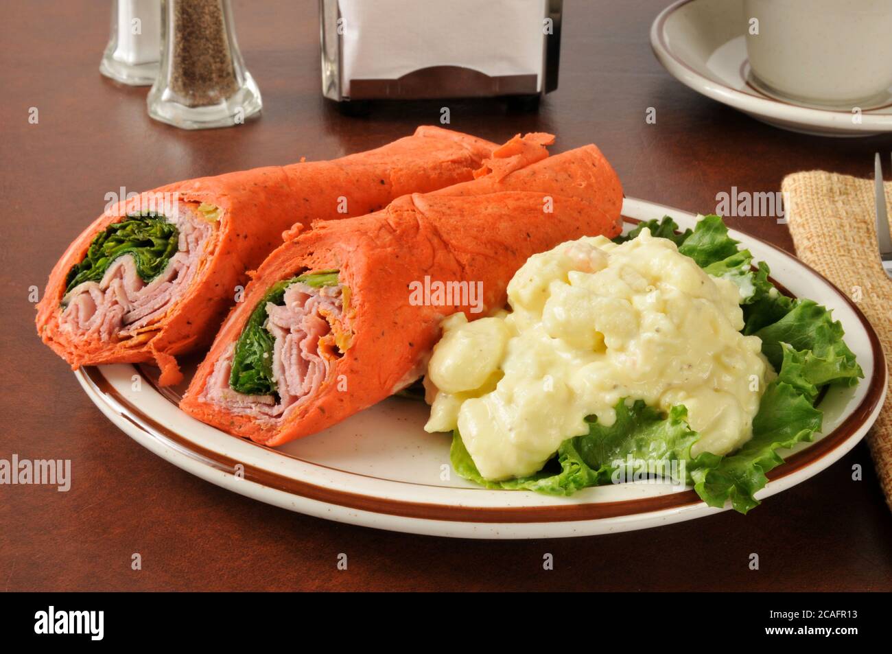 Wrap sandwich with ham, pepperoni, salami, and romaine lettuce Stock