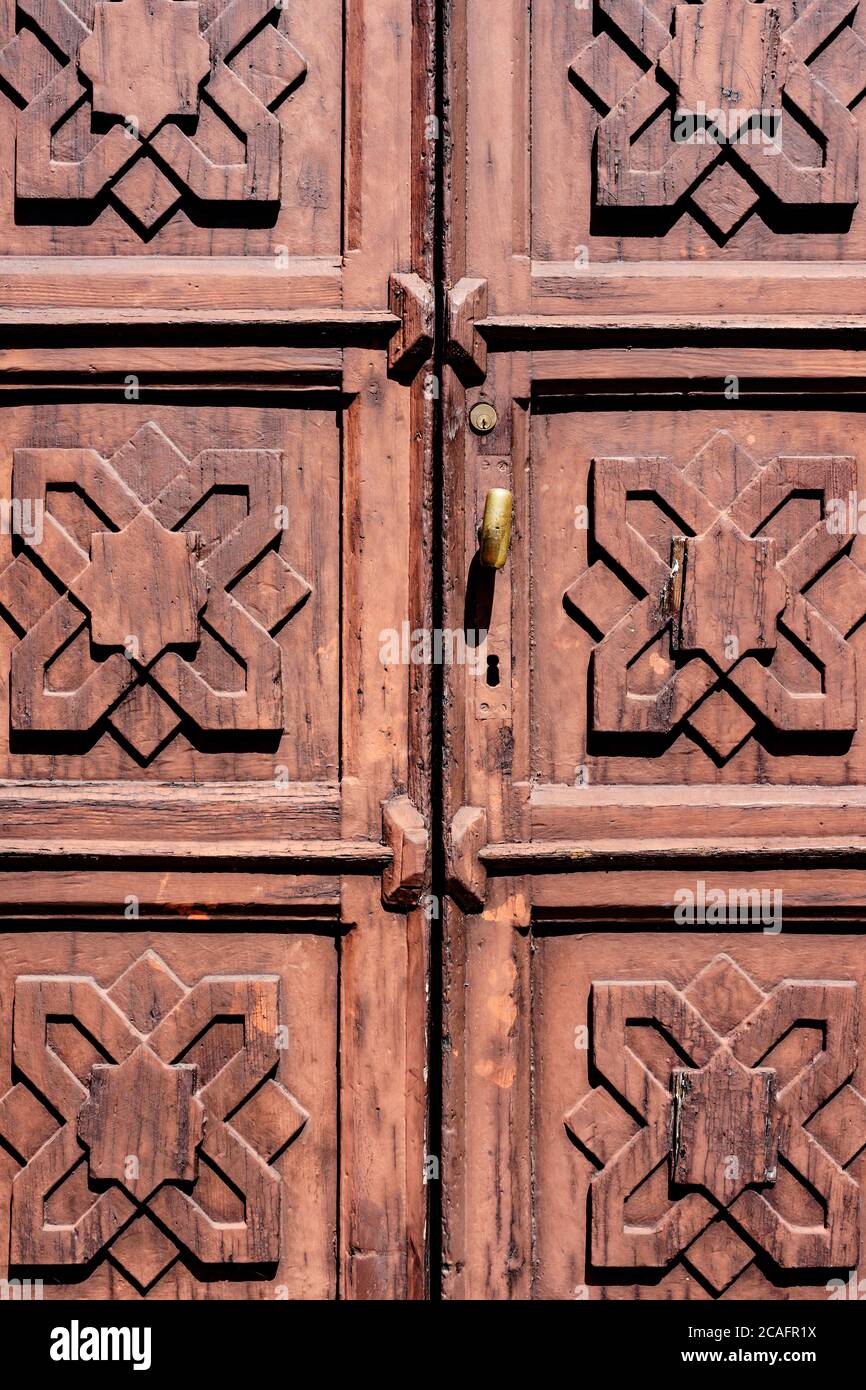 Wooden brown doors with square patterns and metal handle. Stock Photo