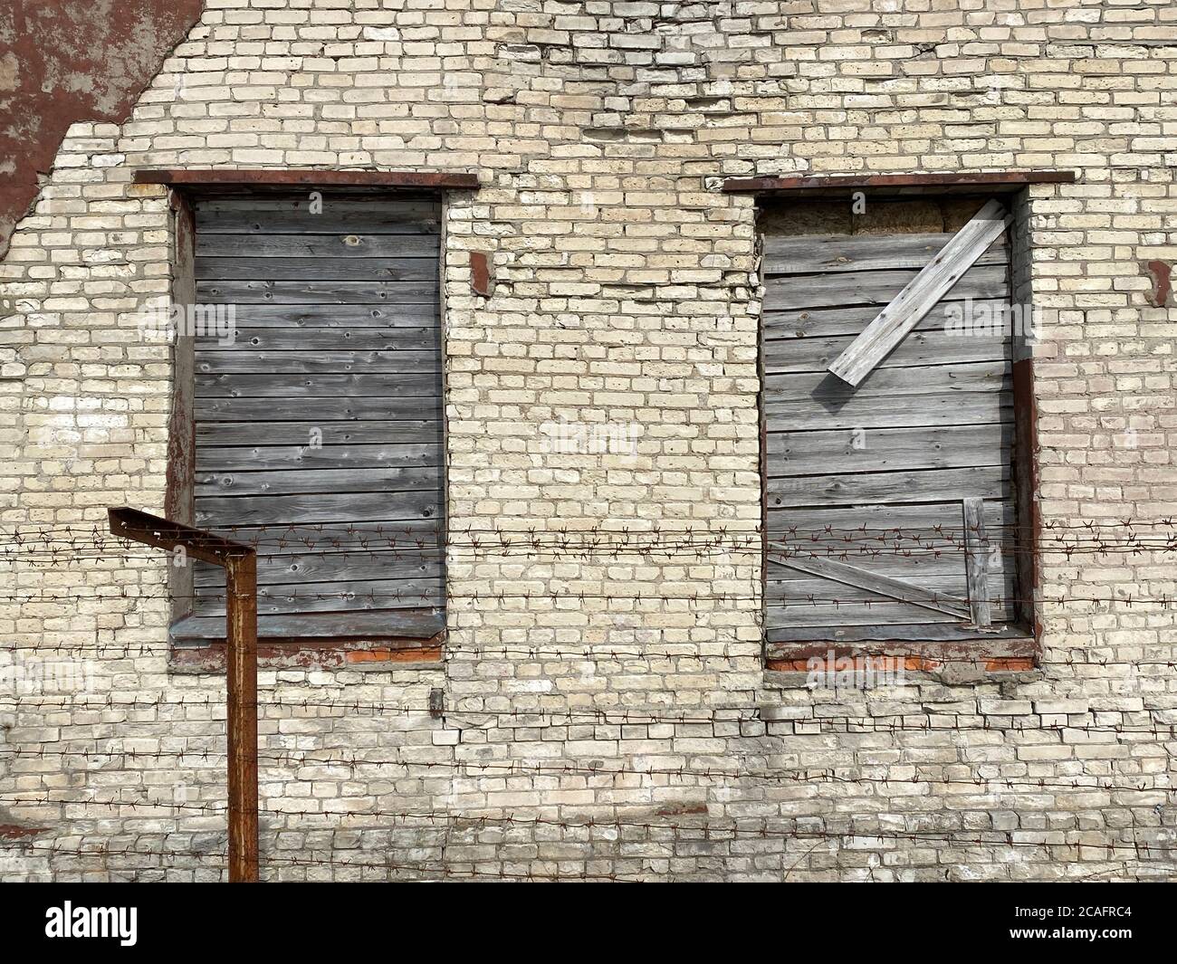 old abandoned brick building with boarded up windows close up Stock Photo