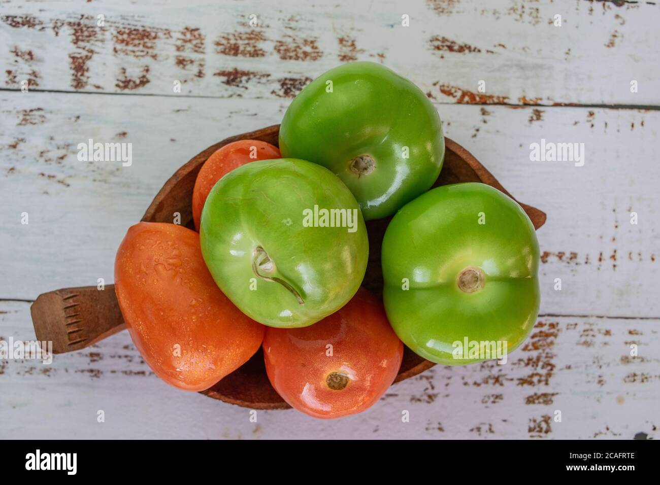 organic tomatoes and tomatillos on vintage table Stock Photo