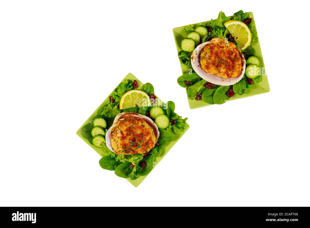 Stuffed clams with crabmeat, minced shrimps and bread crumbs with fresh salad and lemon isolated on white background. Seafood concept. Stock Photo