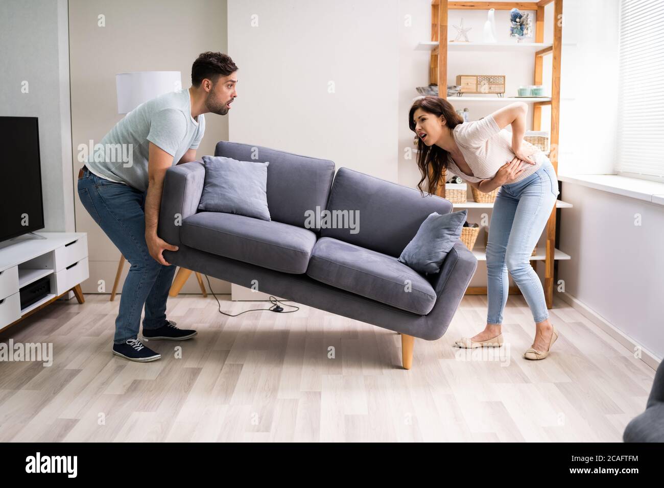 Woman lifting couch hires stock photography and images Alamy